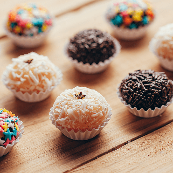 Brigadeiro e beijinho em mesa de festa.